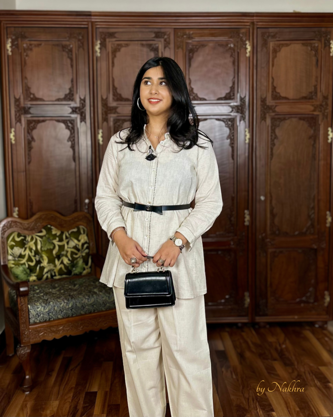 Ivory khadi co-ord set with black bow belt in side view showing relaxed fit and contrast stitch lines